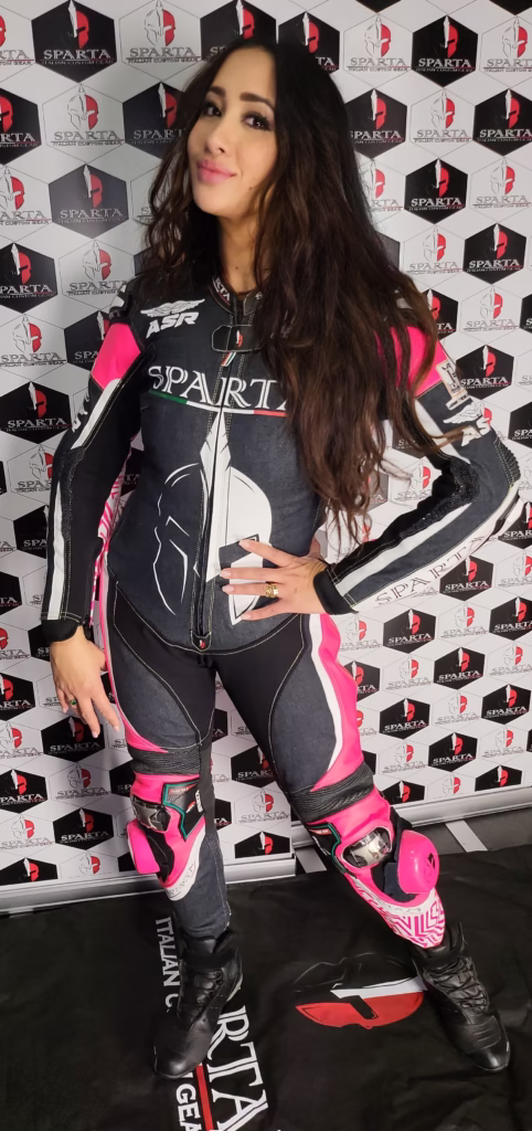 Ragazza biker con tuta Sparta nera e rosa su misura nel showroom BeSparta – abbigliamento moto personalizzato donna - Personalizzato BeSparta Verona